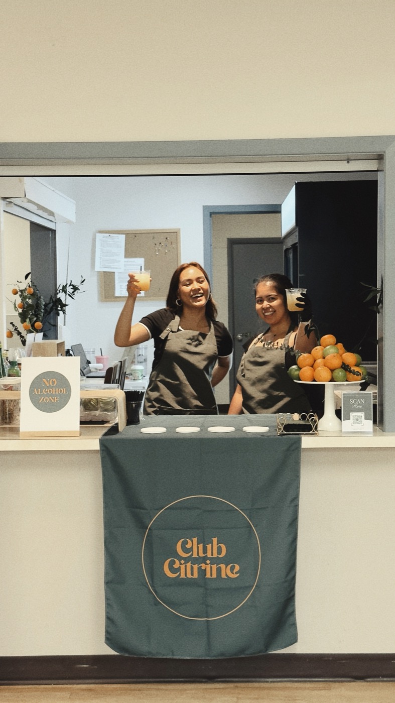 The Club Citrine team behind their branded bar at a Calgary market.