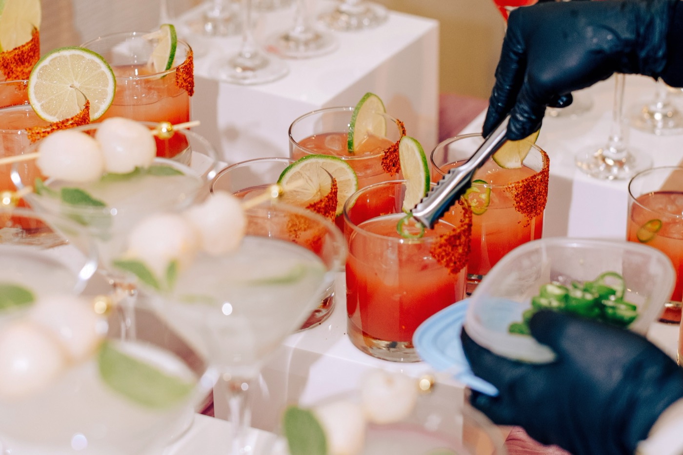 Mocktails being garnished along a market bar.