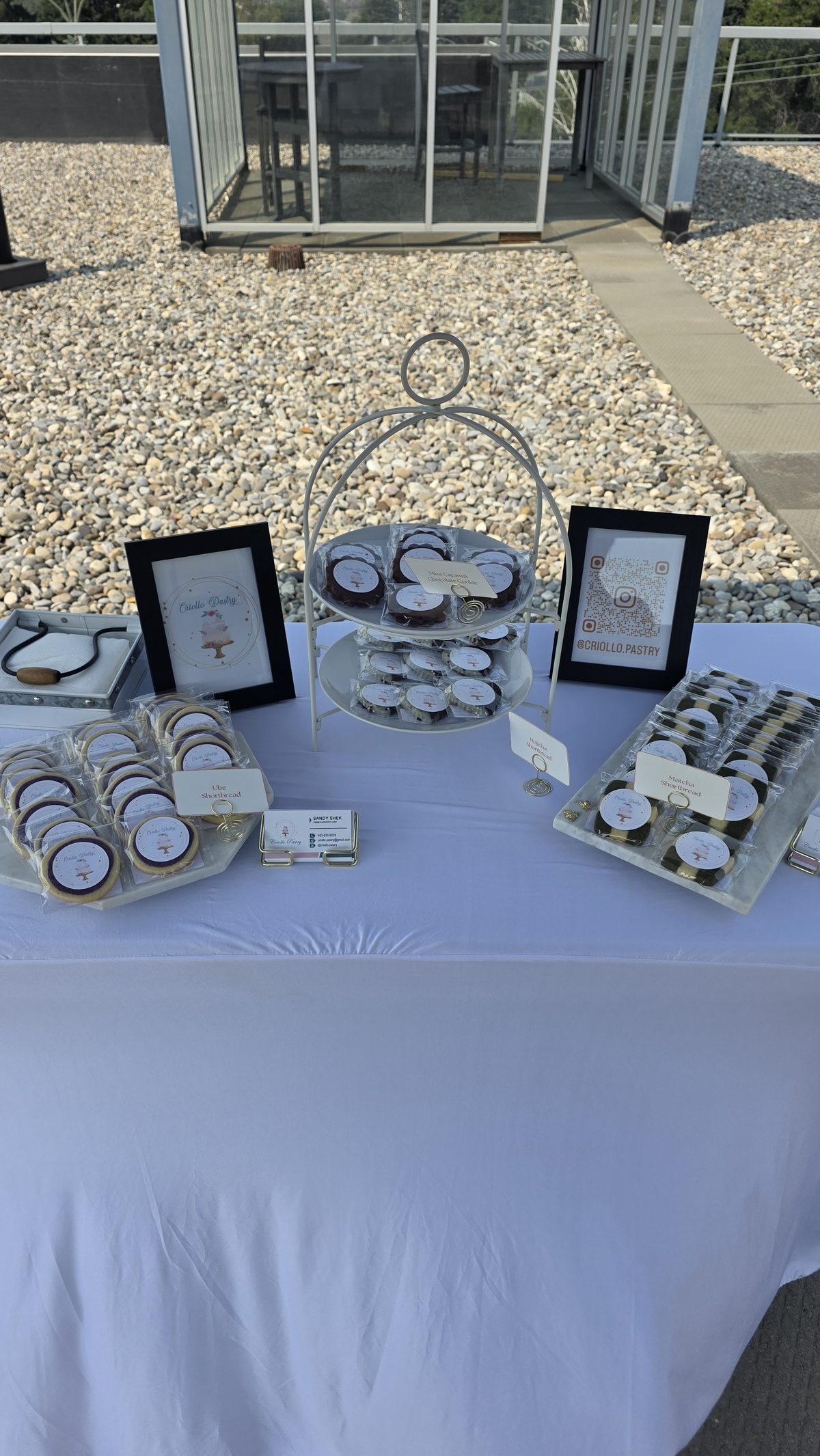 A Criollo Pastry market table set with boxed treats and signage.