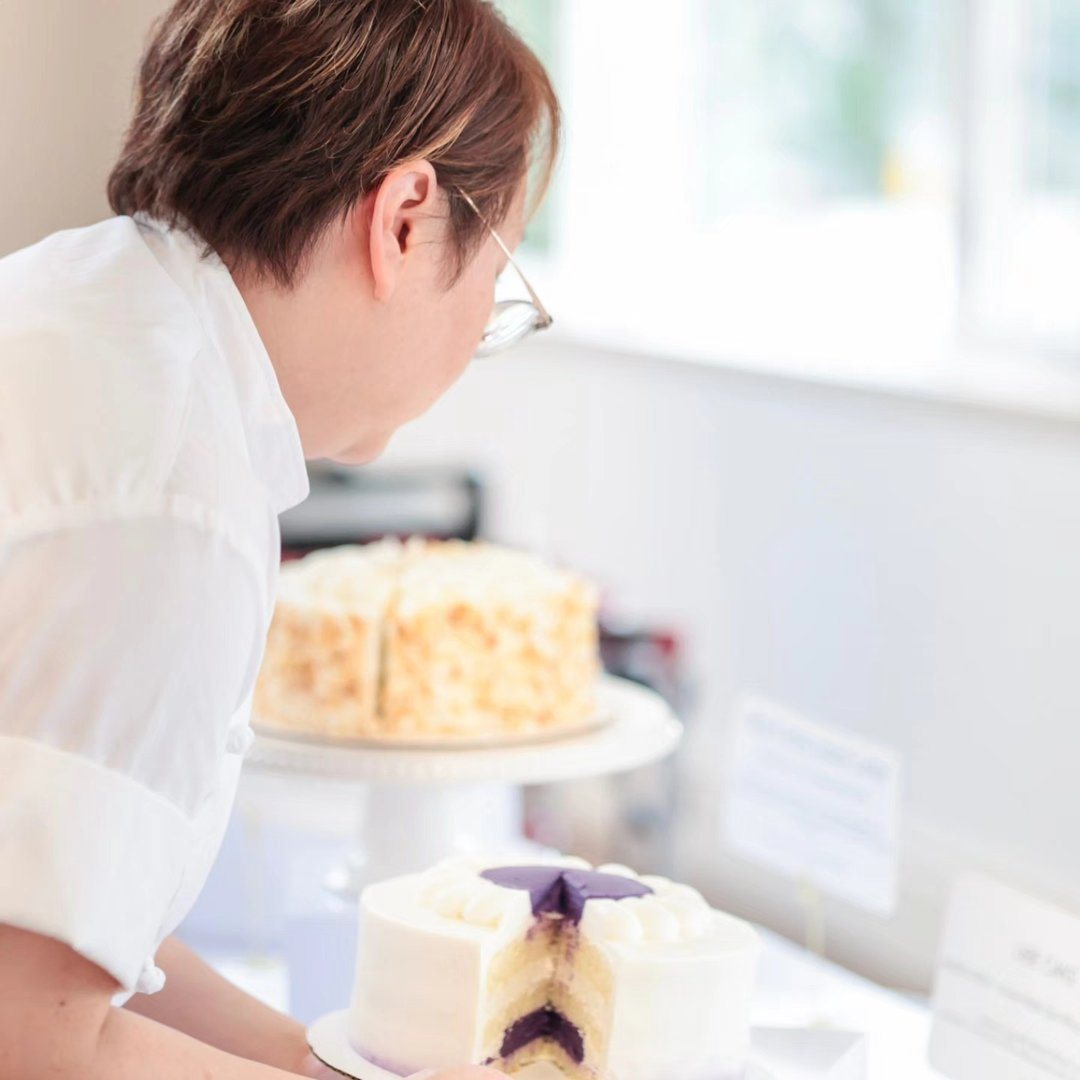 Sandy of Criollo Pastry finishing a cake in her kitchen.
